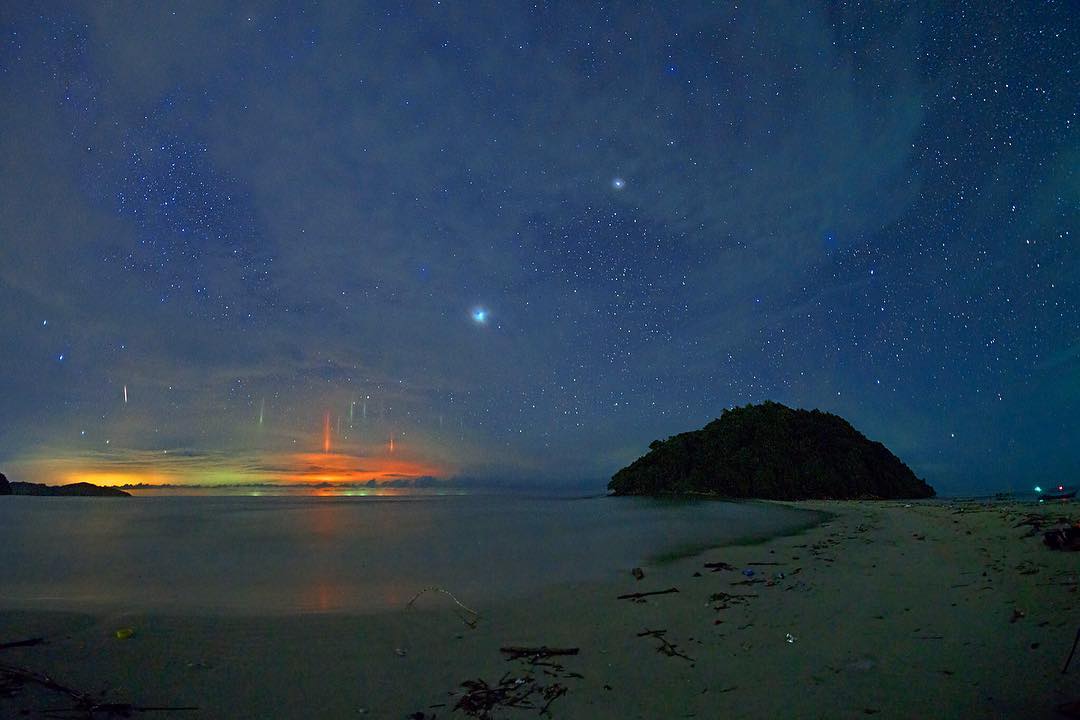 Полярное явление в тропиках: Аномальные световые столбы появляются в небе Борнео.